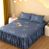 A set of three blue fitted bed sheets with white embroidered fish patterns on a bed.