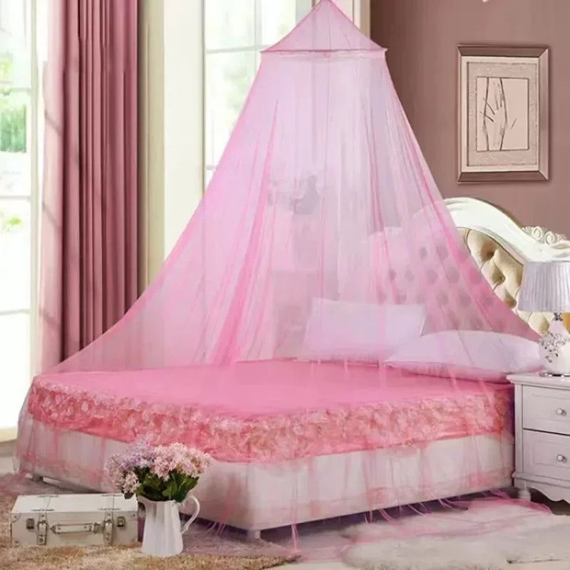 A pink princess dome mosquito net covering a bed, with sheer fabric and pink bedding.