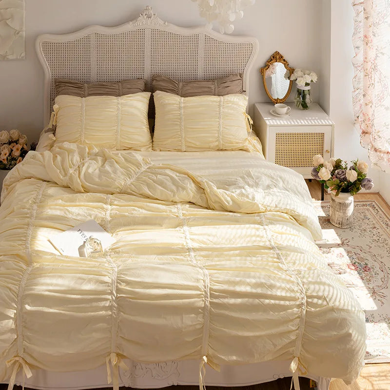 A luxurious set of pure white princess ruffle cotton bedding featuring layered fabric and decorative pillows.