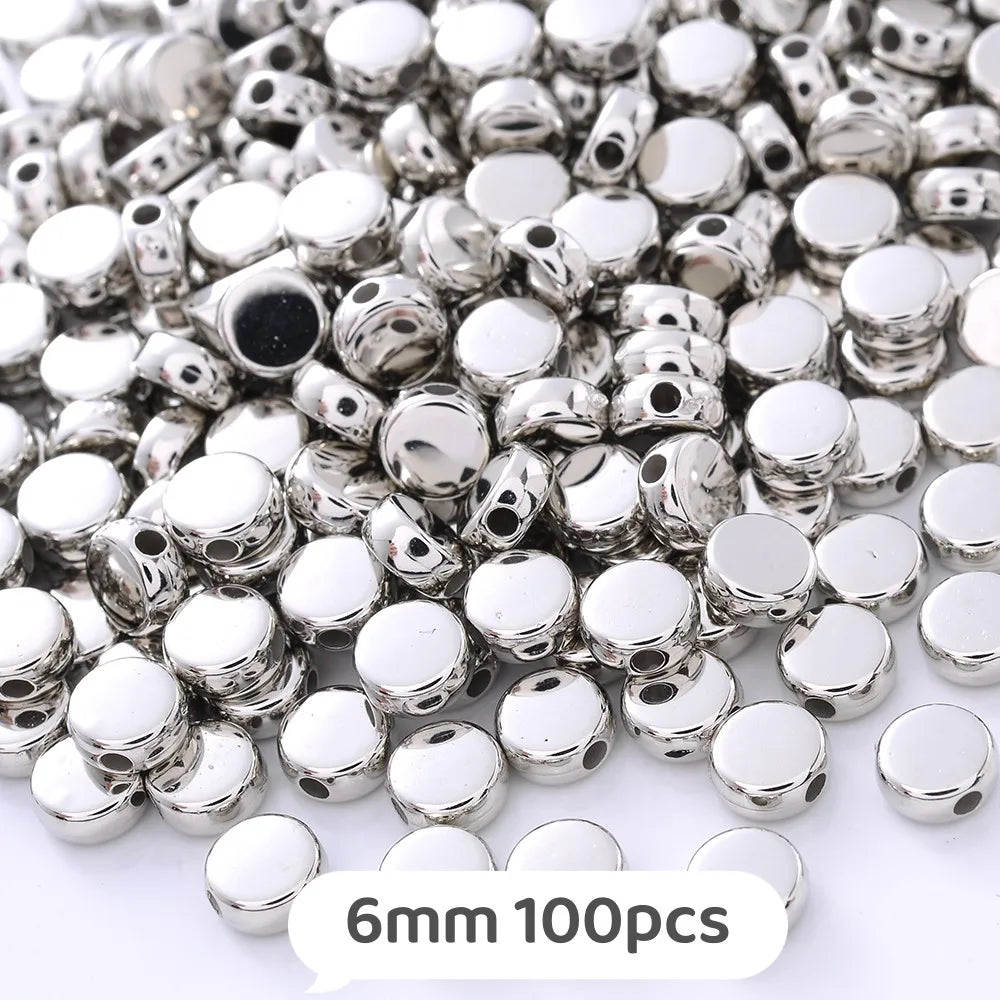 A pile of silver-colored geometric acrylic beads for jewelry making