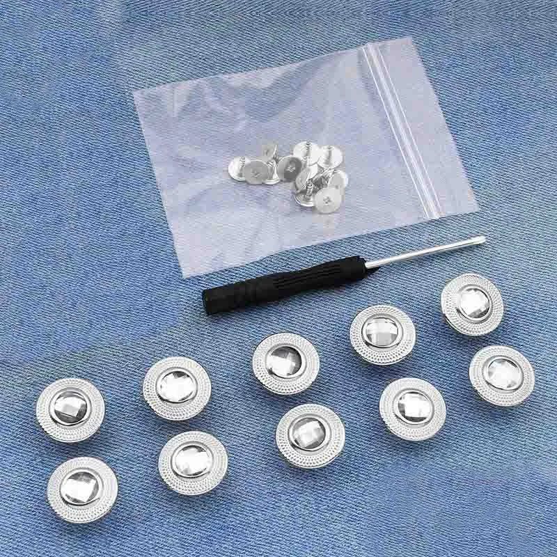 A collection of silver metal button pins laid on a translucent bag against a blue denim background.