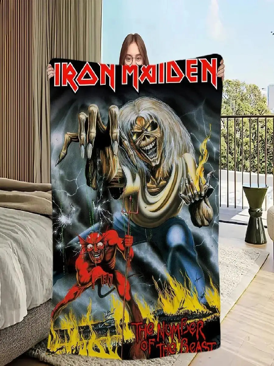 A dark graphic print featuring a skeletal devil with flames, displayed as a blanket.