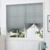 Gray non-woven pleated blackout curtains covering a window with a white frame.