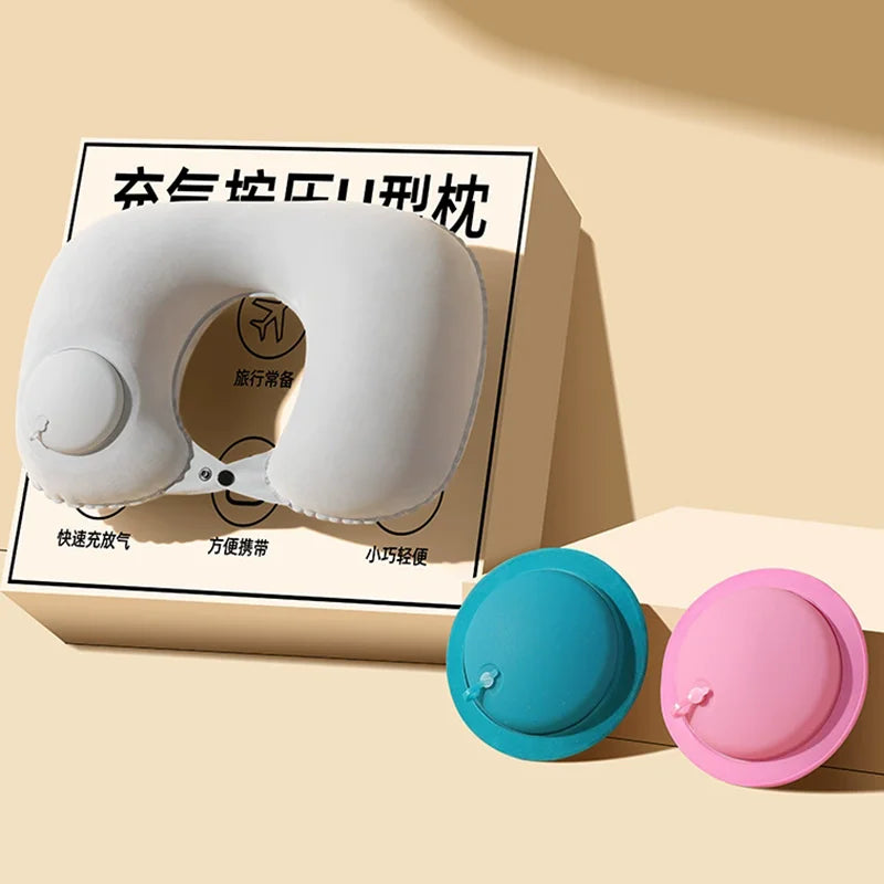 A white inflatable U-shaped travel pillow is shown next to its components, including a blue and pink neck support pad.