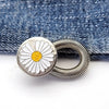 Silver daisy-shaped extender buttons with coiled wire, placed on a blue denim fabric.