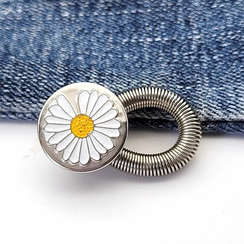 Silver daisy-shaped extender buttons with coiled wire, placed on a blue denim fabric.