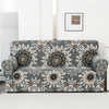 A gray sofa covered with a floral patterned fabric featuring brown and cream designs.