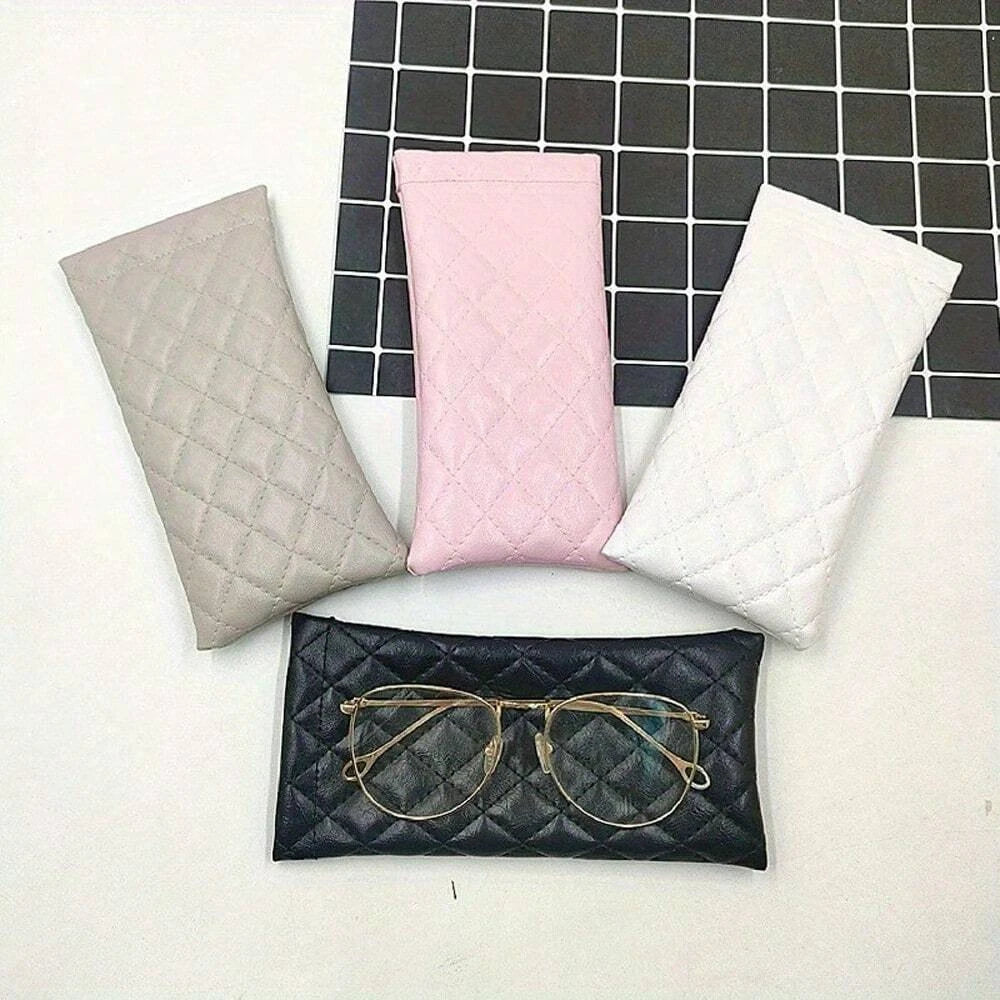 Pink and gray suede-like squeeze-top PU leather eyeglass cases with matching cleaning cloths displayed on a dark grid.