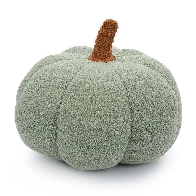 A soft, textured, light green plush pumpkin throw pillow with a brown stem.