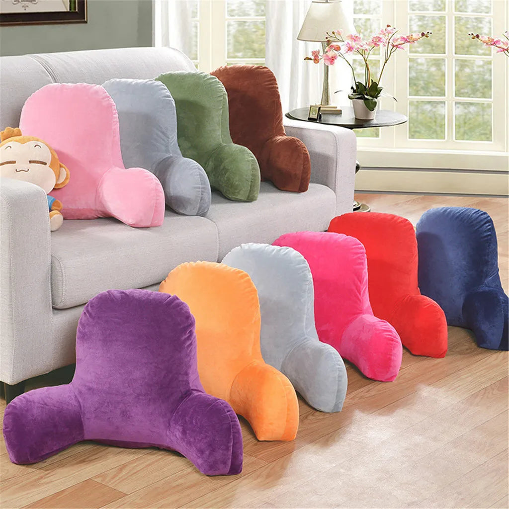 A collection of colorful plush lumbar support cushions in shades of pink, purple, green, orange, and blue displayed on a sofa