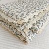 Folded floral print muslin blanket with delicate lace trim