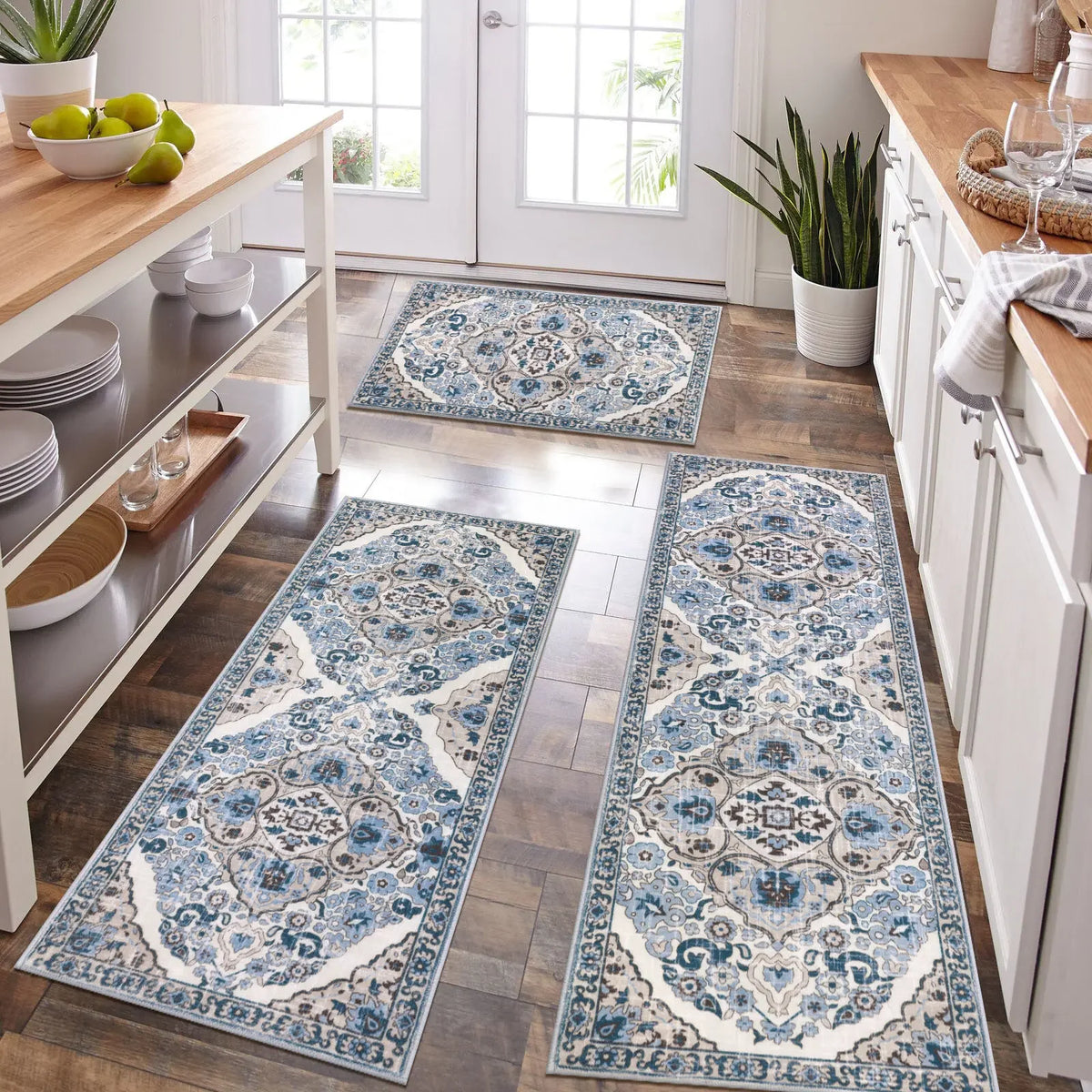 A set of blue and white patterned bohemian anti-slip floor rugs laid out on a wooden floor.