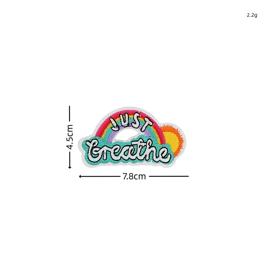 An embroidered patch featuring the text Just Greathe in rainbow colors.