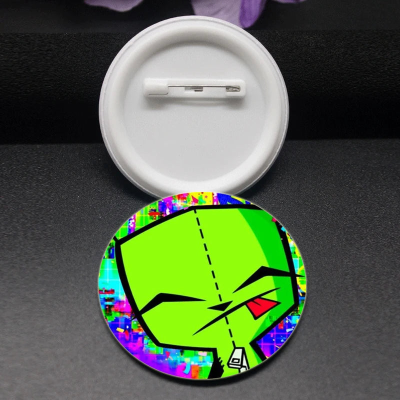 A round enamel pin featuring a stylized green face with black eyes and a red tongue against a colorful background.
