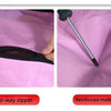 Close-up of a black two-way zipper on a pink fabric bag with a reinforced material detail.