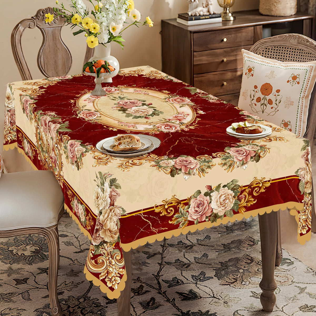 A red and cream floral tablecloth with vintage rose print displayed on a wooden table.