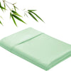 Light green bamboo fiber flat bed sheet folded neatly with green leaves in the background