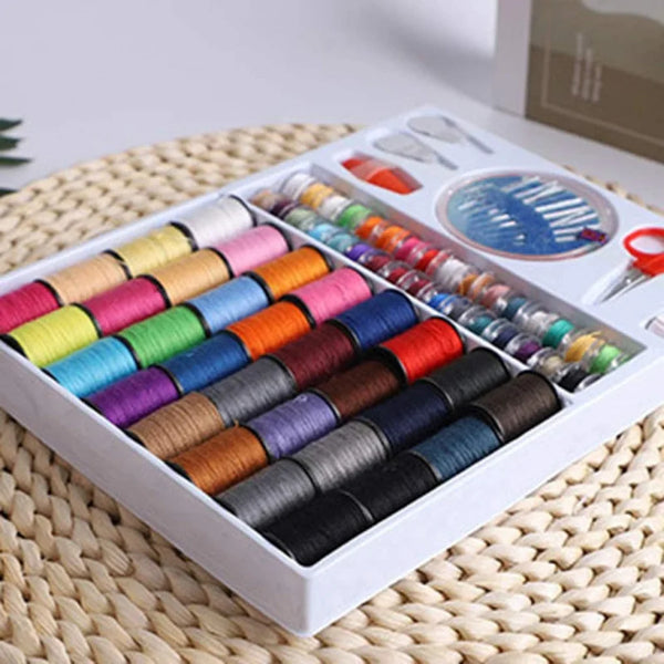 A box containing a variety of colored sewing threads and tools for a DIY kit.
