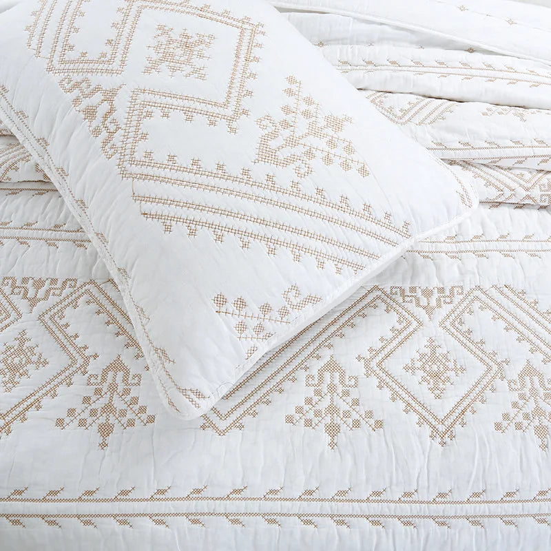 White Nordic cotton embroidered bedding set featuring geometric patterns and stitching.