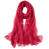A vibrant red sheer scarf draped and folded, suitable for sensory play.