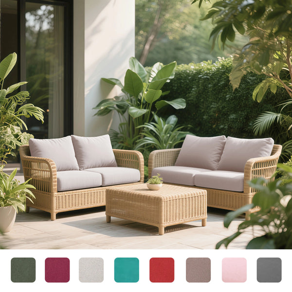 A beige outdoor wicker sofa set with light cushions and a matching coffee table set in a lush garden setting.