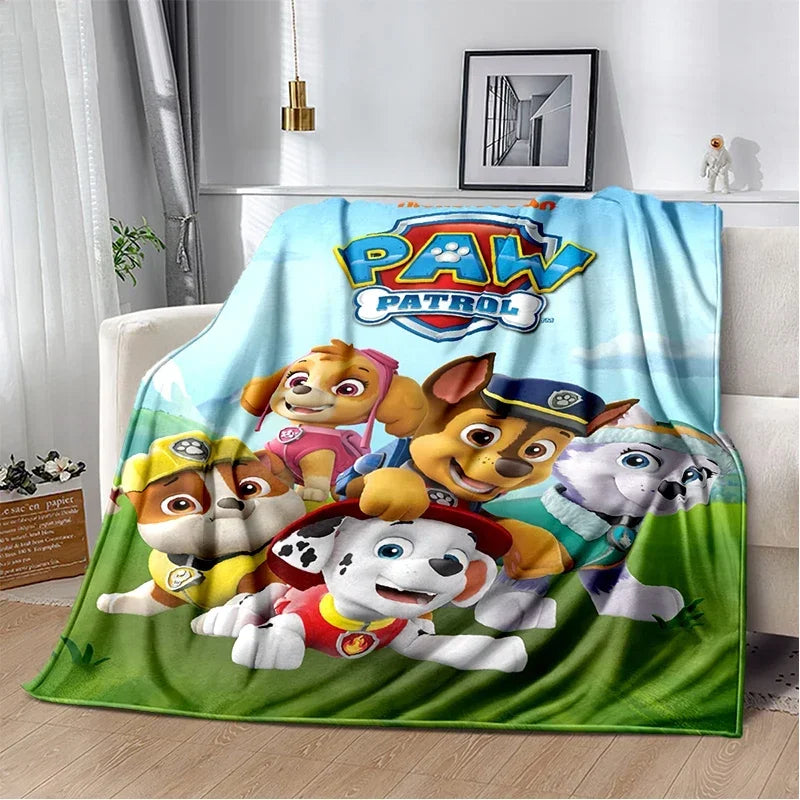 A colorful Paw Patrol themed flannel throw blanket featuring cartoon dogs in various poses.