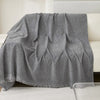 A gray waterproof chenille sofa cover draped over a white sofa.