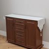 A wooden cabinet with a white embroidered lace table runner on top, used for dining or furniture accents.