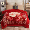 A vibrant red weighted blanket with a floral pattern is displayed on a bed.