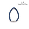 A close-up of a sapphire blue braided cord with silver magnetic clips used as curtain tiebacks.