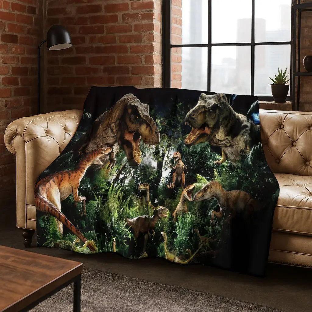 A dark green and black print of various Jurassic Park dinosaurs on a flannel throw blanket.