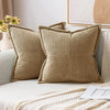 A set of beige striped corduroy lumbar support pillows resting on a light-colored sofa.