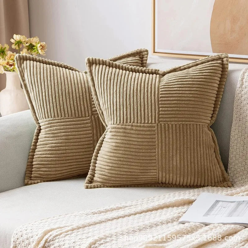 A set of beige striped corduroy lumbar support pillows resting on a light-colored sofa.