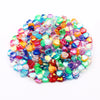 A pile of multicolored acrylic heart beads in various shades of pink, blue, green, and orange.