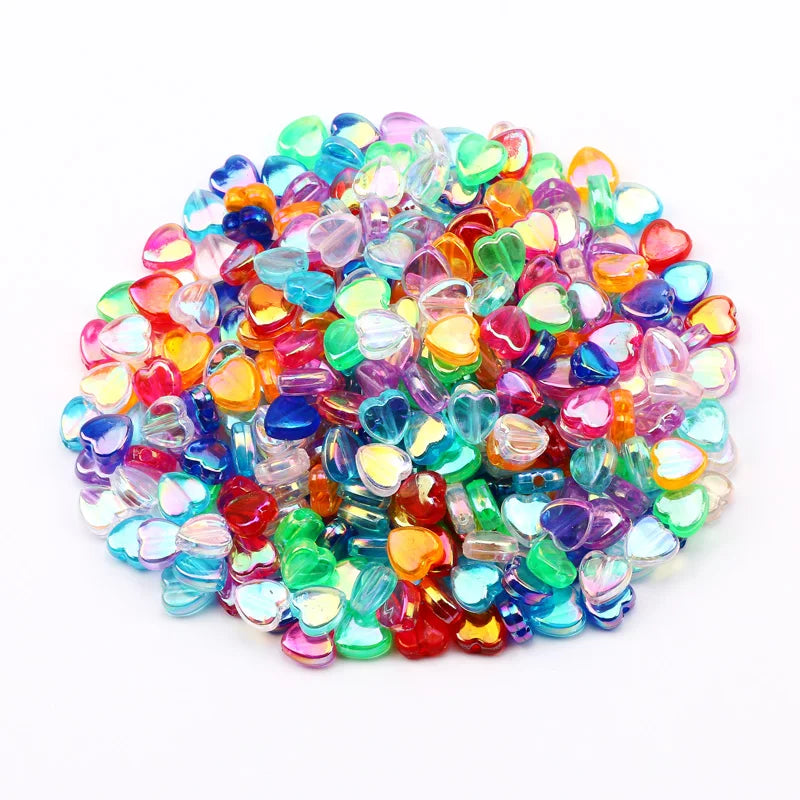 A pile of multicolored acrylic heart beads in various shades of pink, blue, green, and orange.
