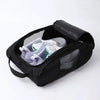 Black shoe carrier bag with a padded lid holding a pair of light-colored athletic shoes.