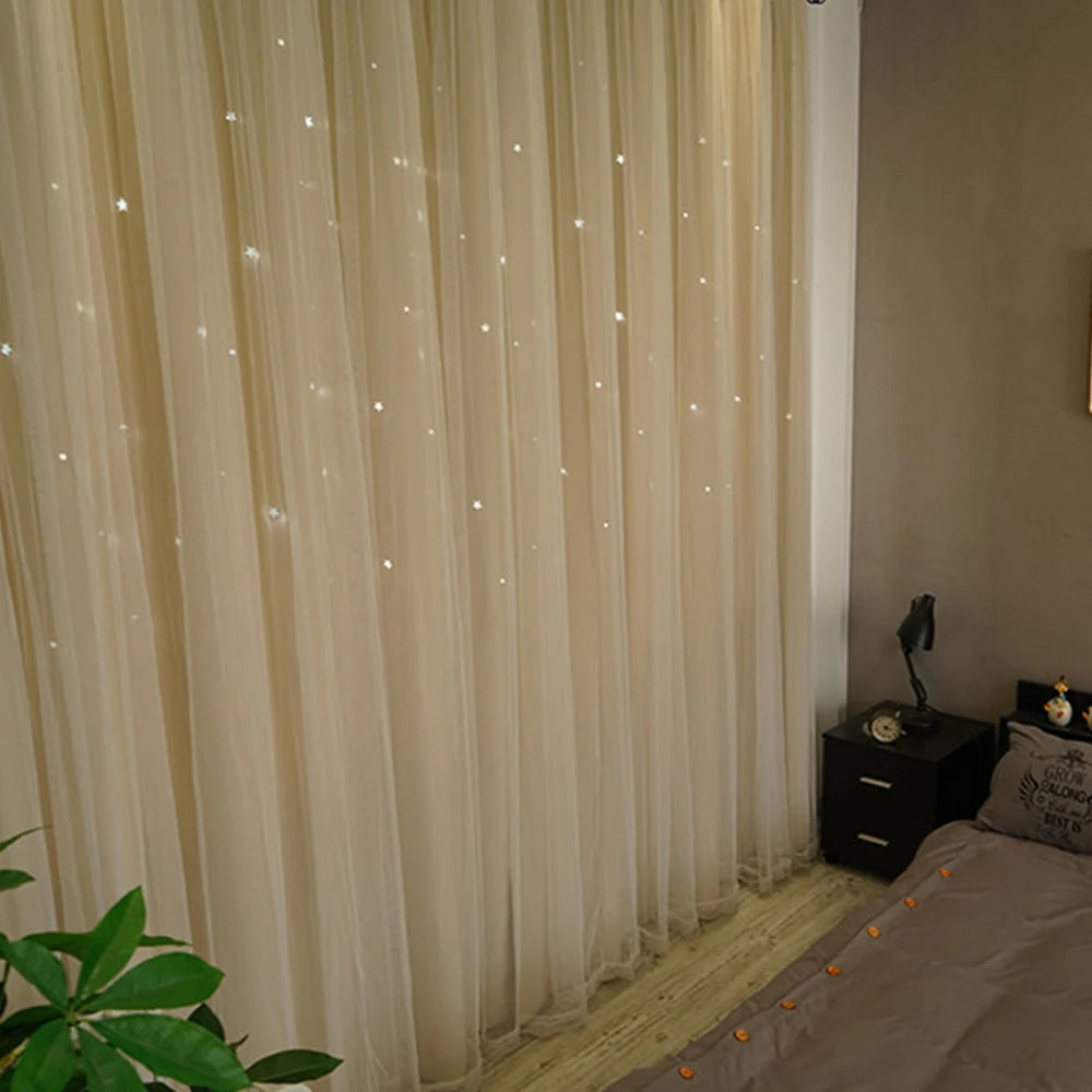 Light beige sheer curtains with a star pattern overlay hanging in a room.