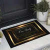 A rectangular gold framed entrance door mat with the text Our Family and a circle of strength on a black background.