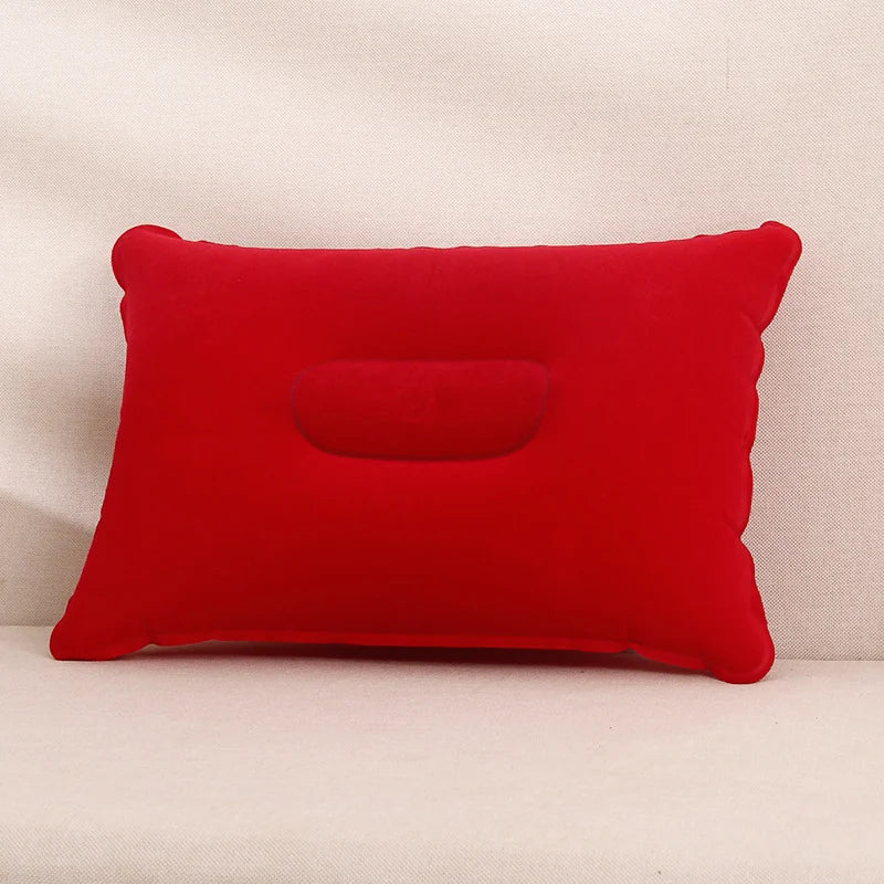 A bright red inflatable travel neck pillow resting on a light-colored surface.