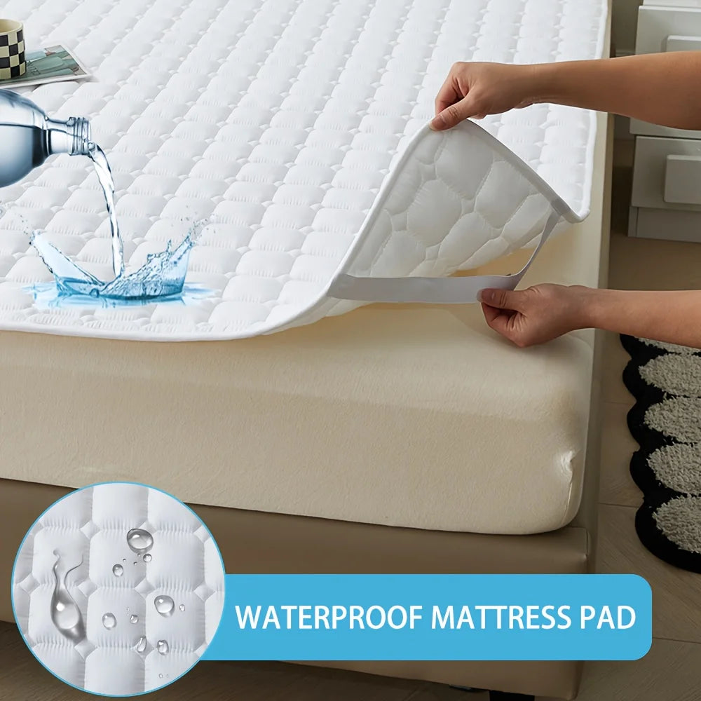 A hand is lifting a white waterproof quilted mattress pad from a bed, demonstrating its protection.