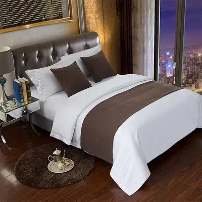 A luxurious bed with white linens and brown accents, featuring decorative bed flags for pillows.