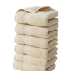 A stack of six beige premium pure cotton face towels folded neatly.