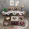 A set of two pillowcases and one quilt cover featuring a patchwork design with hearts in various earthy tones