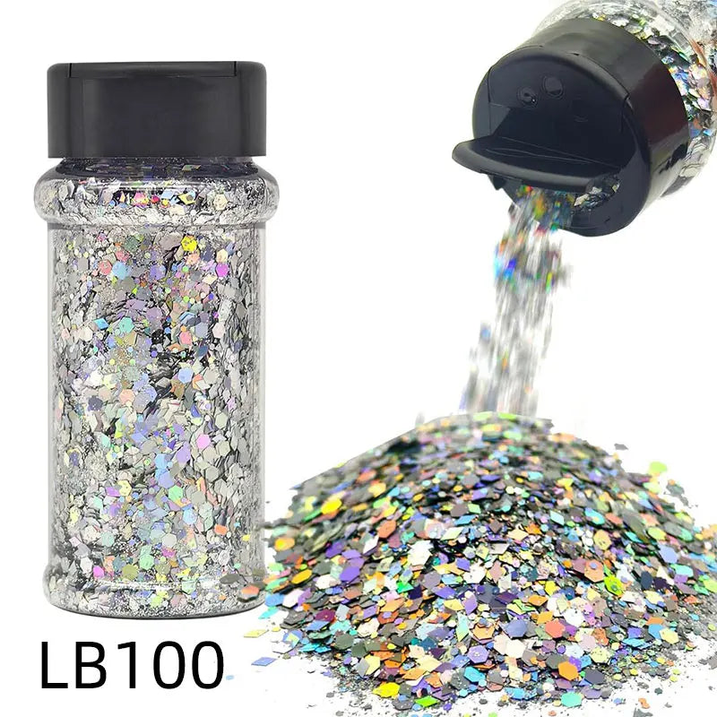 A glass bottle of holographic craft nail glitter mix next to a scoop of iridescent glitter.