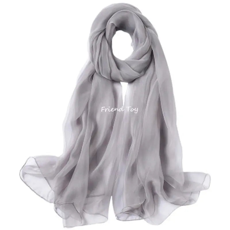 A sheer gray scarf draped and folded, suitable for sensory play.
