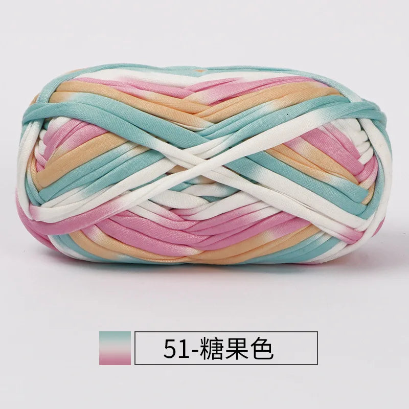 A ball of hand-dyed fabric strip yarn featuring pastel pink, peach, and mint green colors.