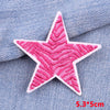 Pink embroidered star patch on blue denim fabric