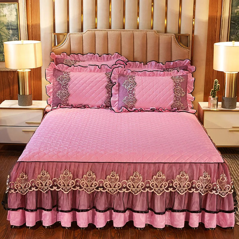 Pink quilted bed skirt set with matching pillowcases and a pink quilted bedspread.