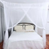 A queen size mosquito net canopy draped over a bed with white bedding and pillows.