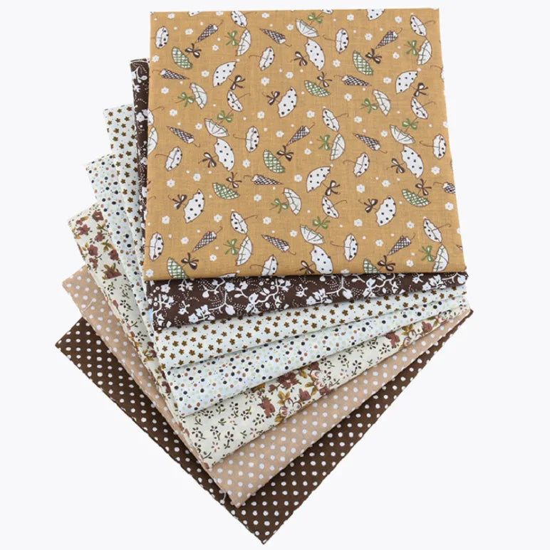 A stack of floral dot pattern cotton fabric squares in various earthy tones and textures.